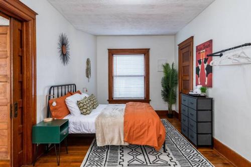 una camera da letto con un letto con lenzuola arancioni e una finestra di Amazing One Bedroom, Queen Bed, Washer & Dryer a Dayton