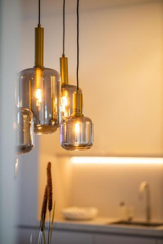 a group of lights hanging over a kitchen counter at The Harbour luxurious, use of hotel swimming pool and sauna in Cadzand