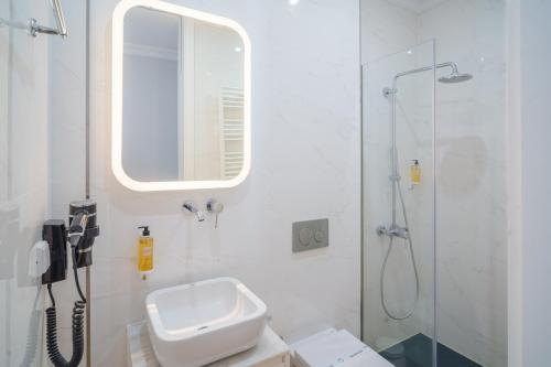 a bathroom with a sink and a shower with a mirror at Feel Porto Downtown Apartments & Studios in Porto