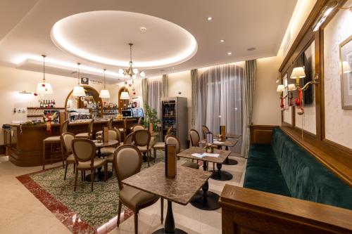 un restaurante con mesas y sillas y un bar en Hungarikum Hotel, en Lakitelek