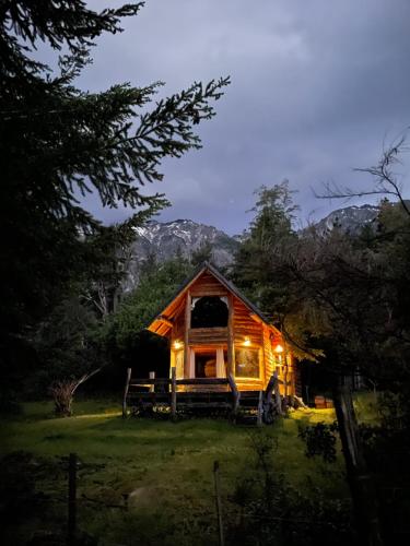 una cabaña en el bosque por la noche con luces en Cabaña Don Ramon - Puerto Patriada en El Hoyo