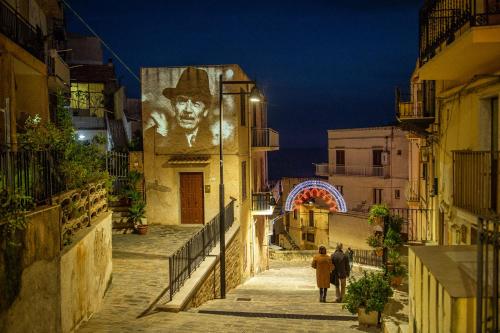 a group of people walking down a street at night at B&B Porta di Mare in Sciacca