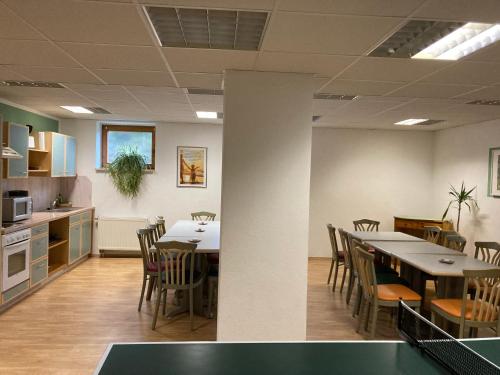 a room with a table and chairs and a kitchen at Wohlfühlherberge Weitblick in Erlbach