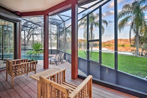 a screened in porch with two benches and windows at Riverfront DeLand Home with Pool, Near Daytona! in DeLand