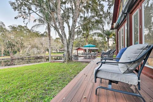 a porch with two chairs on a wooden deck at Riverfront DeLand Home with Pool, Near Daytona! in DeLand