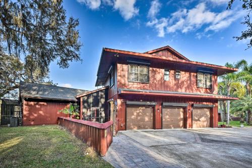 a red barn with two garage doors and a driveway at Riverfront DeLand Home with Pool, Near Daytona! in DeLand