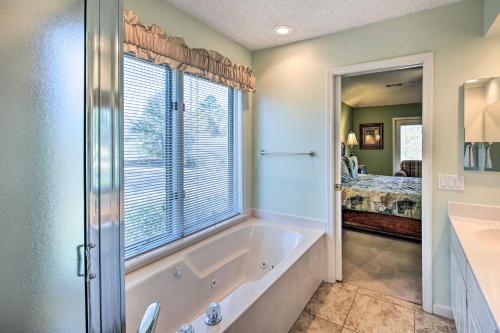 a bathroom with a tub and a window at Lovely Hot Springs Home with Lake Balboa Access in Hot Springs Village