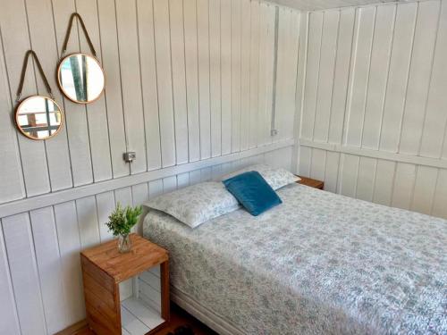 1 dormitorio con cama y espejo en la pared en GREEN HOUSE - com linda vista para o mar, en Palhoça