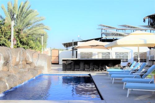 a swimming pool with chairs and a piano at Refael Garden Villa 
