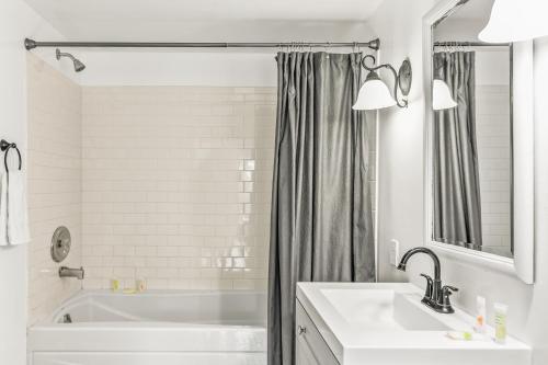 a white bathroom with a tub and a sink at Summerland Lookout in Summerland