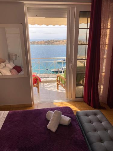 een slaapkamer met uitzicht op de oceaan vanaf een balkon bij Two Islands in Pákhi