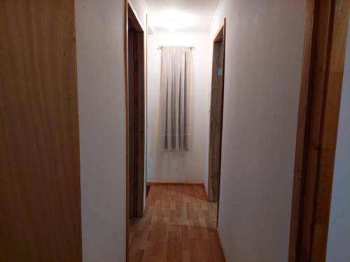 pusty korytarz z dwoma otwartymi drzwiami i drewnianą podłogą w obiekcie Cabañas Nelly w mieście Frutillar