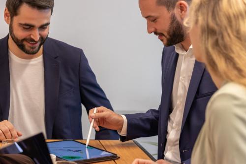 two men in a meeting looking at a tablet computer at Businesshotel Forum Widnau in Widnau