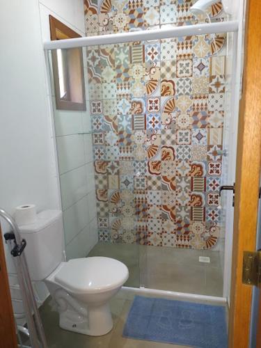 a bathroom with a toilet and a shower at Recanto das Amendoeiras in Guarda do Embaú