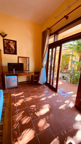 sala de estar con suelo de baldosa y puerta corredera de cristal en Duke Bungalow en Phu Quoc