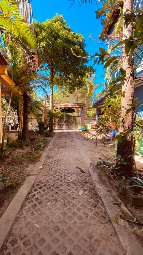 a dirt road with trees and a gate in the distance at Duke Bungalow in Phu Quoc