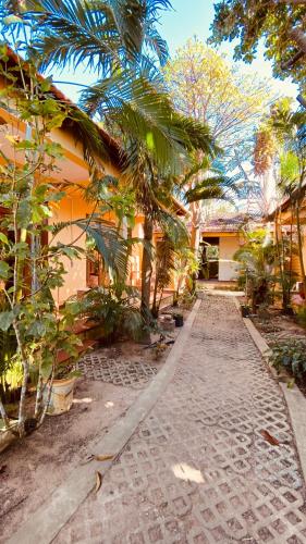 a cobblestone street in front of a house with palm trees at Duke Bungalow in Phú Quốc