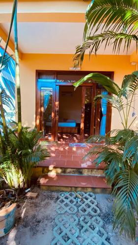 a house with palm trees in front of it at Duke Bungalow in Phú Quốc