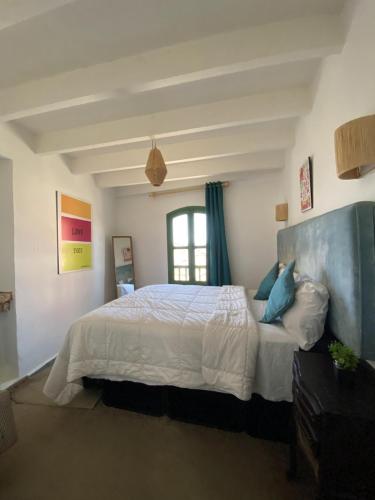 a bedroom with a large white bed with a window at Atlantic Hostel in Essaouira