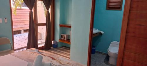 a bedroom with a bed and a bathroom with a toilet at Hotelito Villas Holbox in Holbox Island