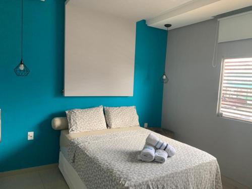 a blue bedroom with a bed with slippers on it at #01 Boulevard Amazon Suites in Manaus