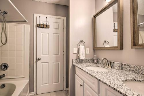 ein Badezimmer mit zwei Waschbecken, einem Spiegel und einer Badewanne in der Unterkunft Veteran-Owned Family Home Near Fort Jackson! in Columbia