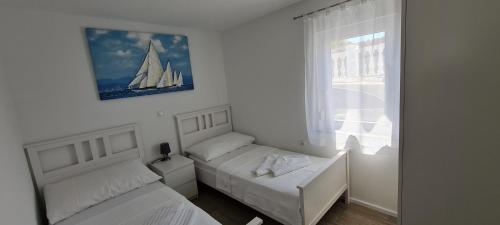 1 dormitorio con 2 camas y un velero en la pared en House Vallis Aurea, en Povile