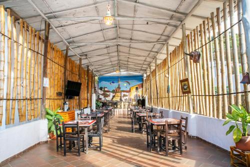 a restaurant with tables and chairs in a room at Hotel Verde Menta in San Gil