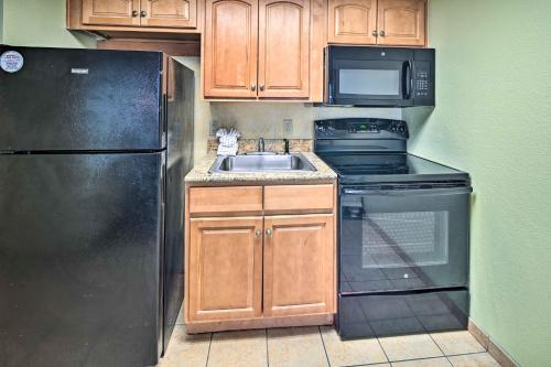 a kitchen with a black refrigerator and a sink at Oceanfront Myrtle Beach Rental with Pool! in Myrtle Beach