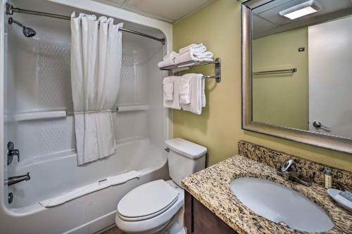 a bathroom with a toilet and a sink and a mirror at Oceanfront Myrtle Beach Rental with Pool! in Myrtle Beach