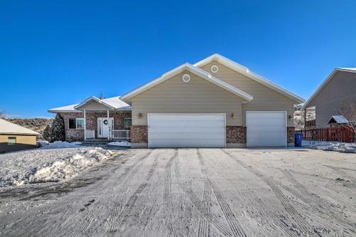 a house with two garage doors on a driveway at Spacious Idaho Home Ski, Hike, and Fish! in Rexburg