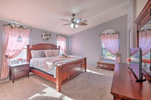Cette chambre comprend un lit avec des rideaux roses et un ventilateur. dans l'établissement Chandler Oasis with Resort-Style Backyard and Pool!, à Sun Lakes