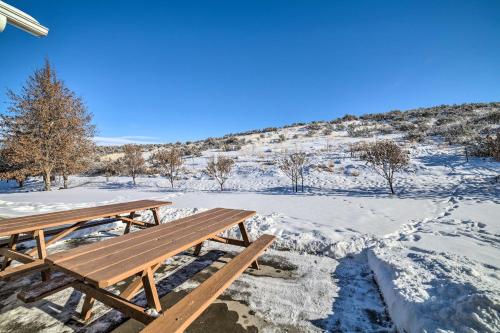 a wooden picnic table sitting on top of a snow covered field at Spacious Idaho Home Ski, Hike, and Fish! in Rexburg