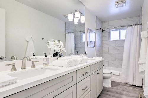 a white bathroom with a sink and a toilet at Peaceful Windsor Retreat with Private Hot Tub! in Windsor