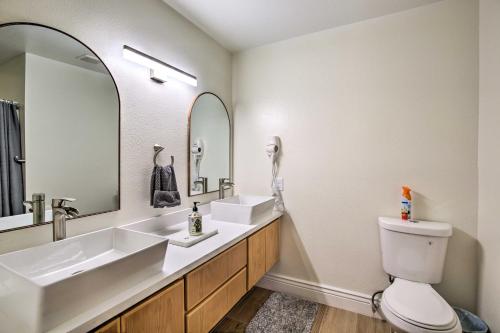 a bathroom with two sinks and a toilet and a mirror at Renovated Yuma Home with Community Pool! in Yuma