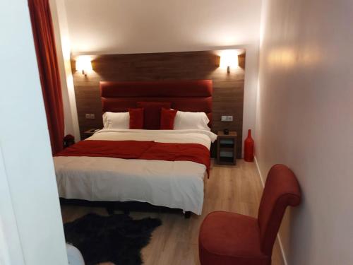 een slaapkamer met een groot bed en een stoel bij Happy land maison Épinay-sur-Seine in Épinay-sur-Seine