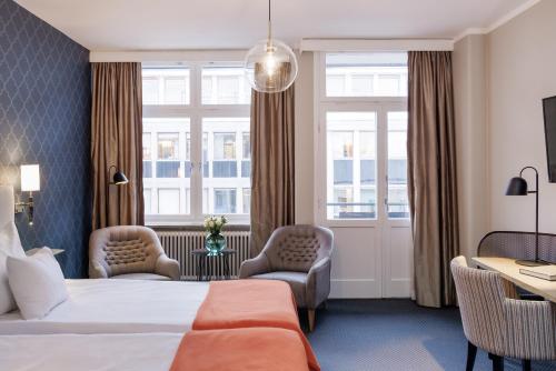 Habitación de hotel con 1 cama y 2 sillas en Clarion Collection Hotel Wellington, en Estocolmo