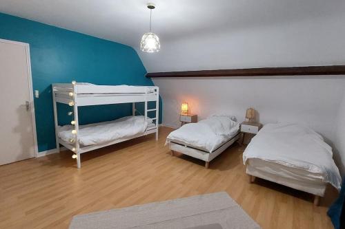 sypialnia z 2 łóżkami i niebieską ścianą w obiekcie La villa du lac à Mesnil Saint Père w mieście Mesnil-Saint-Père