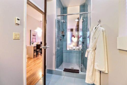 a bathroom with a shower with a glass door at St. James' Gate, Boutique Hotel in Moncton