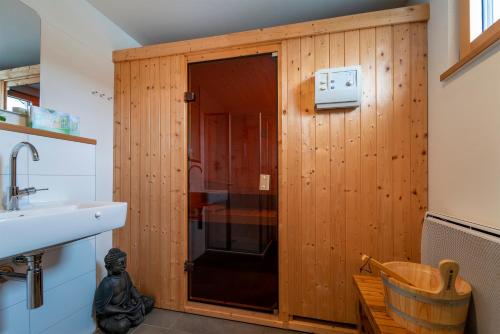 een badkamer met een douche en een houten muur bij Nienhagen in Nienhagen