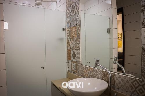 y baño con lavabo y espejo. en Qavi - Apartamento no Centro de Pipa #Solar163, en Pipa