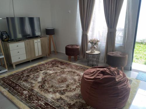 ein Wohnzimmer mit einem TV und einem Teppich in der Unterkunft Villa Adinda Syariah D8 in Tarogong