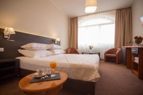 una habitación de hotel con una cama y una mesa con bebidas en Restaurant Pensiune Bucovina, en Câmpulung Moldovenesc