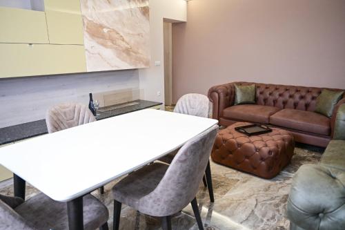 a living room with a table and chairs and a couch at Роял Шумен in Shumen