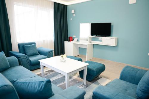 a living room with blue couches and a tv at Роял Шумен in Shumen