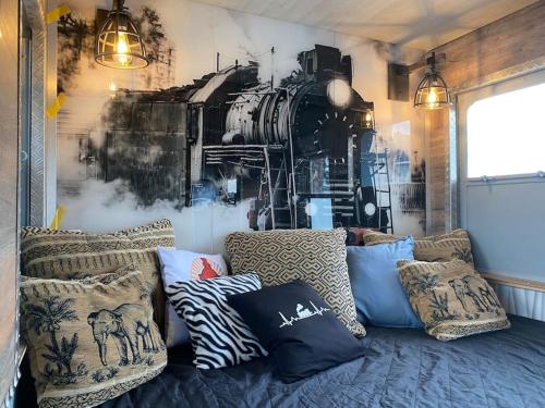 a living room with a couch and a train mural at Gleis 2, Waggon mit Ofen, Whirlpool und Sauna in Dahlem