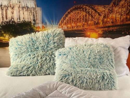 two pillows sitting on top of a bed with a bridge at Gleis 2, Waggon mit Ofen, Whirlpool und Sauna in Dahlem