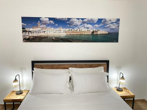 una camera da letto con un letto con due lampade e un dipinto sul muro di Casetta di Gaia a Monopoli