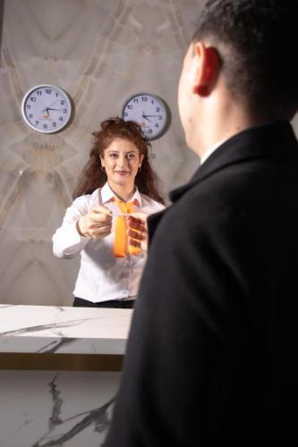 a woman taking a picture of a man in front of a mirror at Mandarinnart HOTEL in Astara