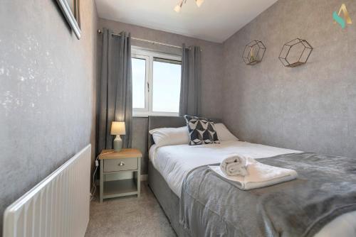 a small bedroom with two beds and a window at Aberdovey House TSAC in Stockton-on-Tees